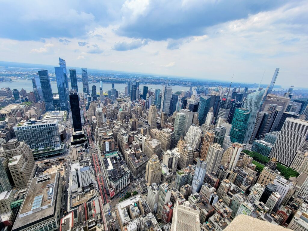 High-angle view of Midtown Manhattan with skyscrapers and Hudson River—highlighting architectural contrast and city planning as one of the hidden gems in New York.